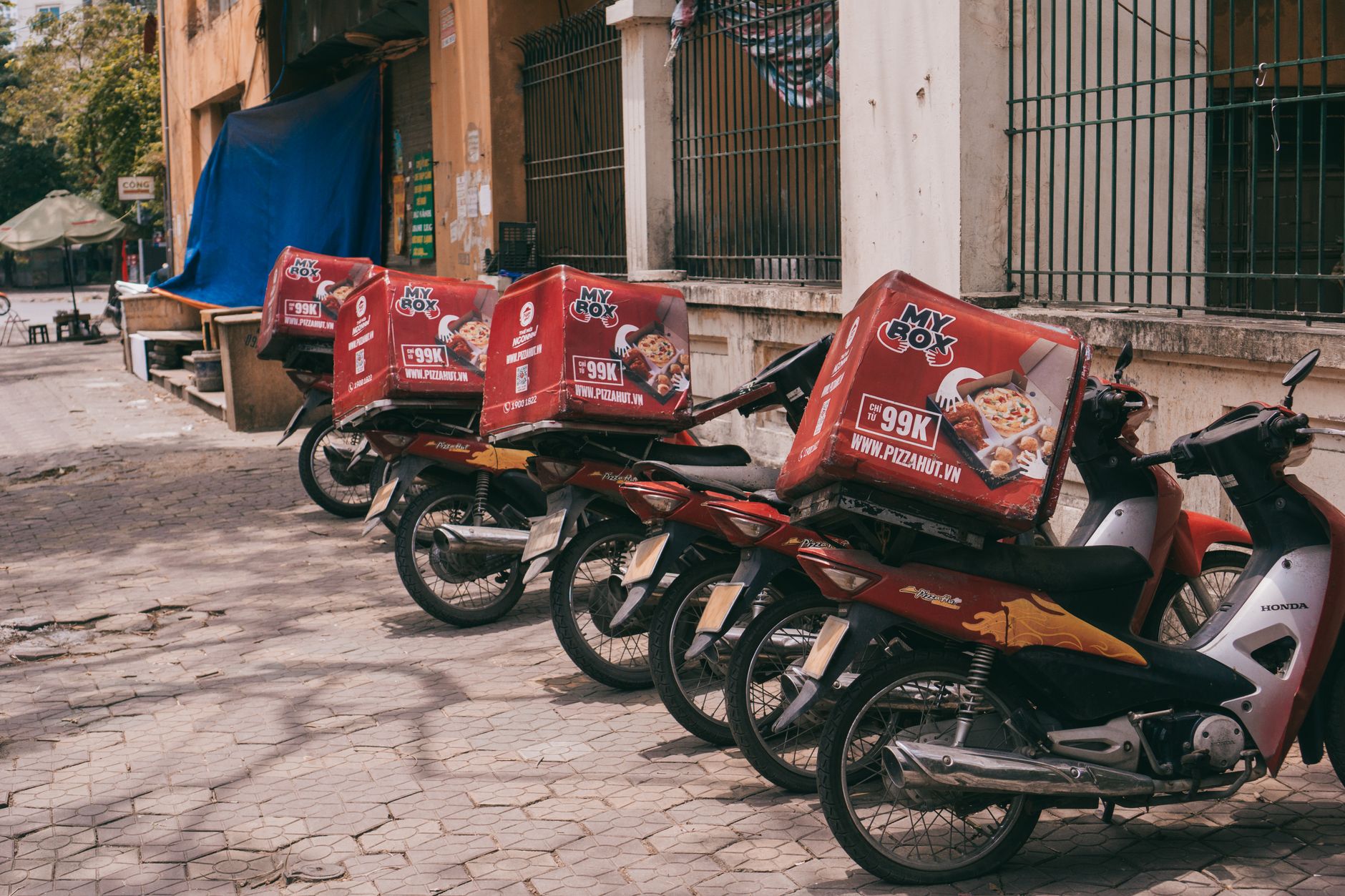 Motoboy de delivery com caixa térmica em frente a restaurante
