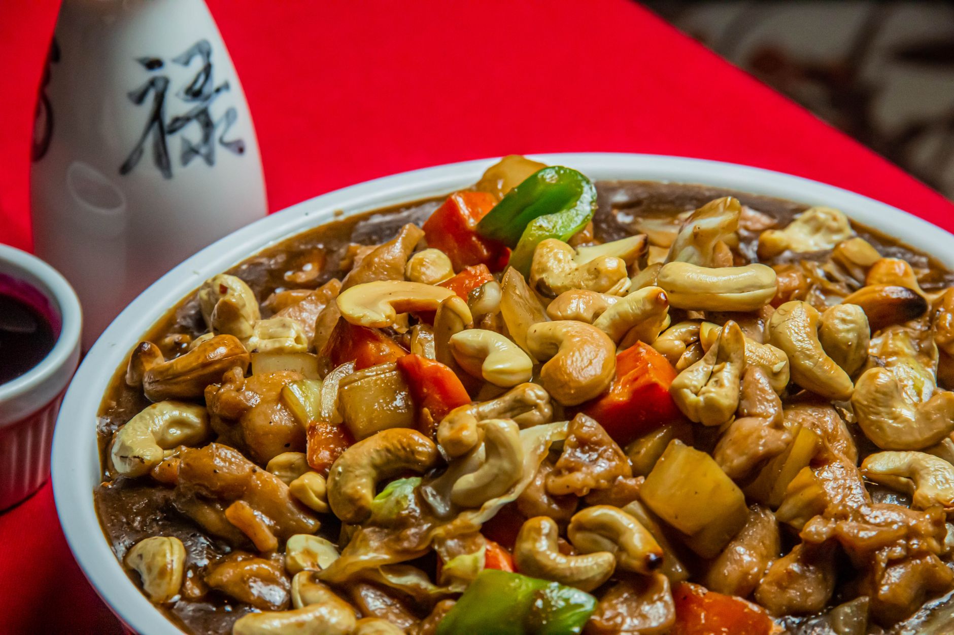 Frango xadrez com pimentões coloridos e amendoim em prato oriental