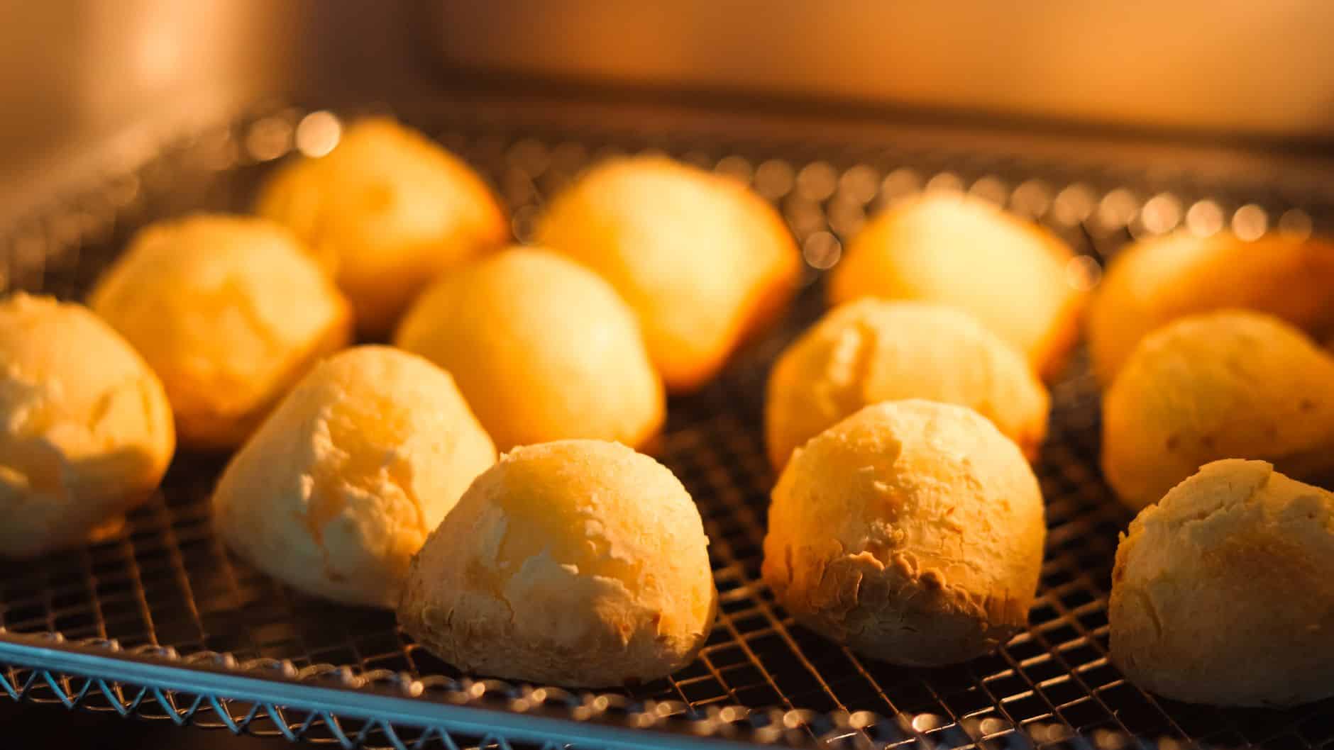 Pães de queijo dourados recém-saídos da airfryer em cesta