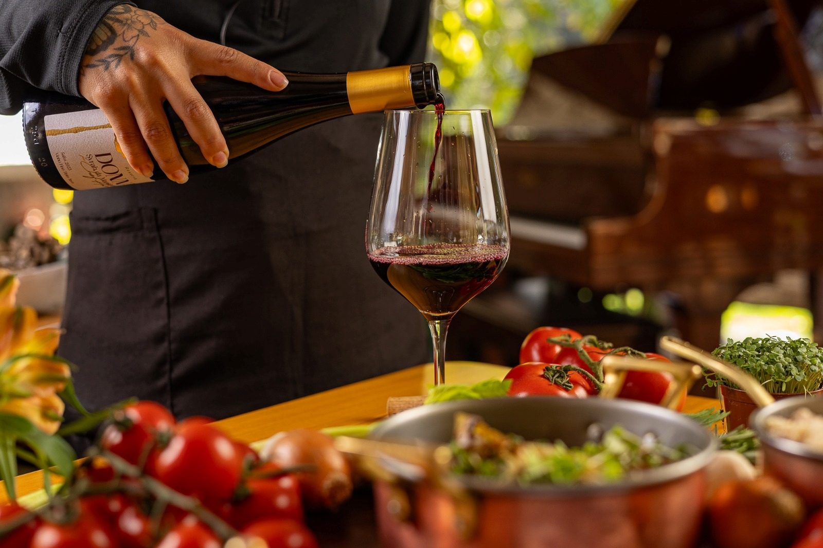 Vinho tinto sendo servido em taça durante almoço harmonizado na Casa Bambuí