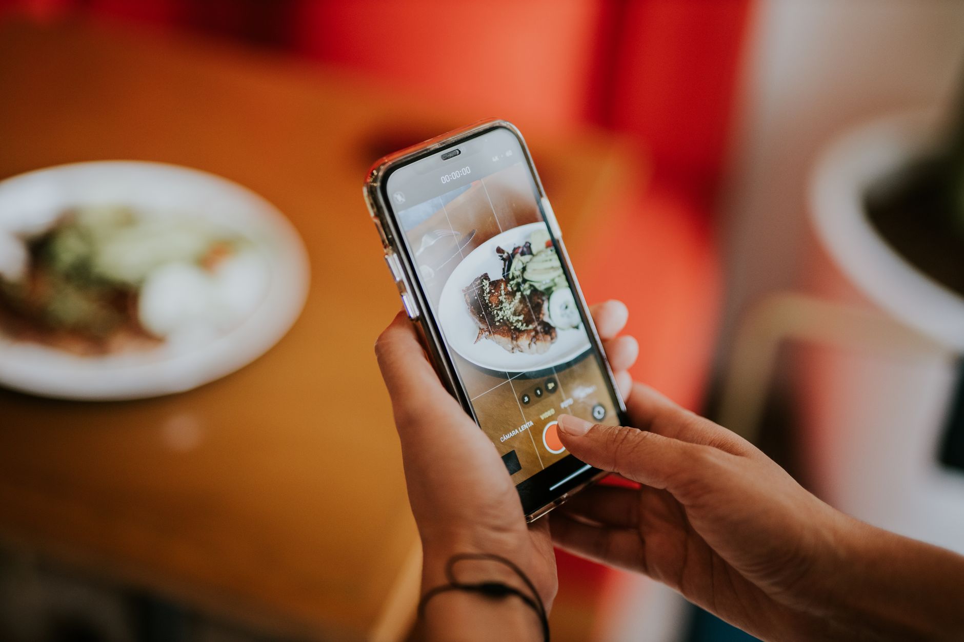 Celular fotografando prato apetitoso em restaurante para redes sociais
