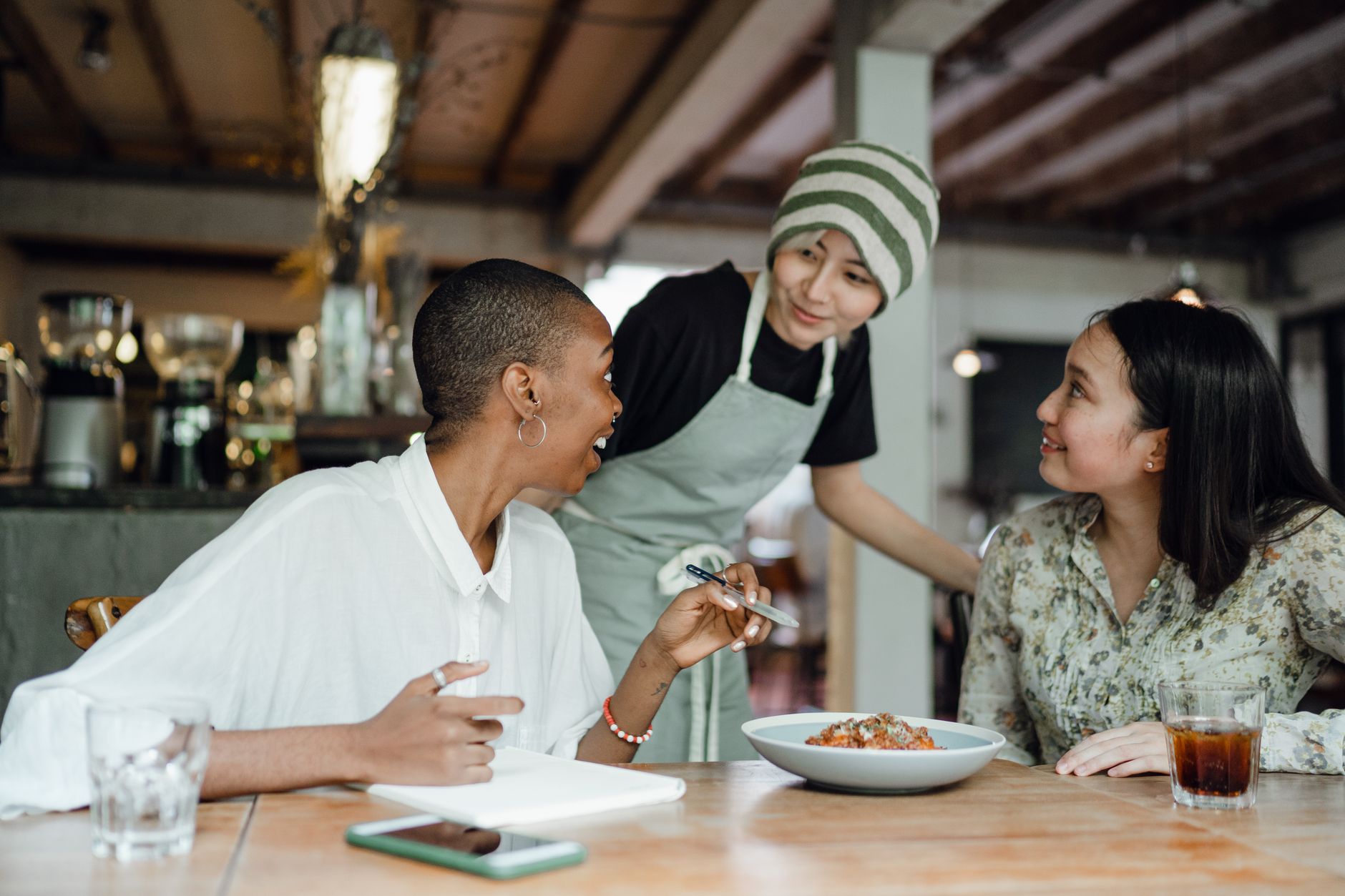 Clientes satisfeitos sendo bem atendidos em restaurante acolhedor