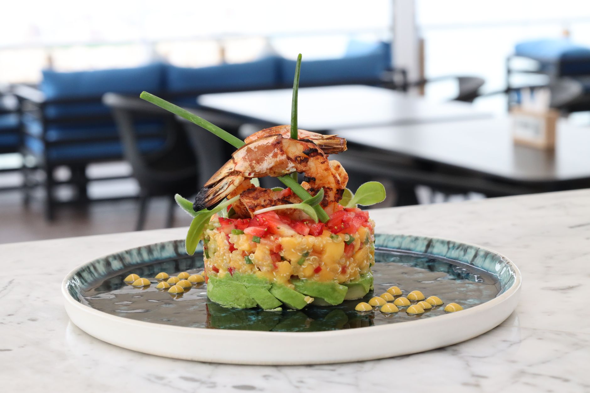 Salada de quinoa com cubos de manga, hortelã e castanhas em tigela
